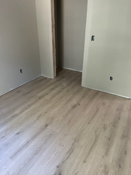 New light oak plank flooring running through a doorway between two rooms