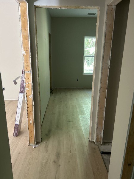 New plank flooring seen through a doorway with the door casing removed