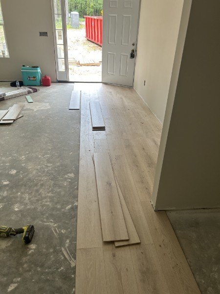 Plank flooring installation in progress at an entry door